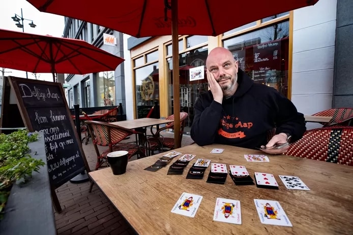 Mark van den Boogaard van de Deftige Aap in Helmond zit op zijn terras te patiencen, nu de horeca geen uitzicht heeft op verruiming van de lockdown. Foto: Rene Manders/DCI Media-AD.