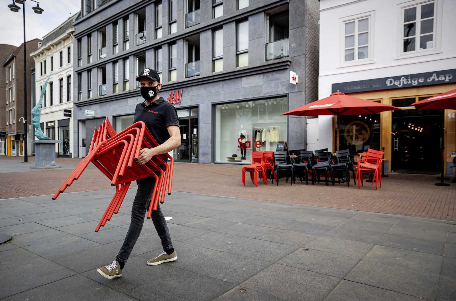 Een terras wordt opgebouwd bij een horecazaak in Helmond. Foto: ANP