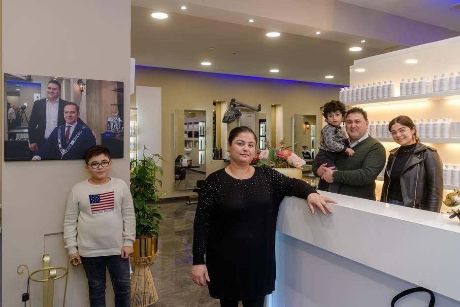 Kappers Safin en Lana moeten schipperen om hun kinderen Yad, Shad en Gelena en hun personeel te onderhouden. Links op de foto staat vaste klant, burgemeester Sjoerd Potters van De Bilt. Foto: Mel Boas/AD.