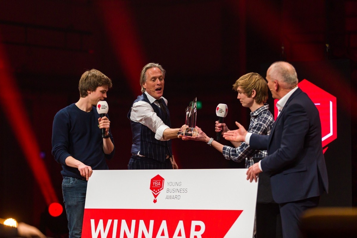 Presentator Jort Kelder feliciteert CodeSandbox met de Young Business Award 2021.