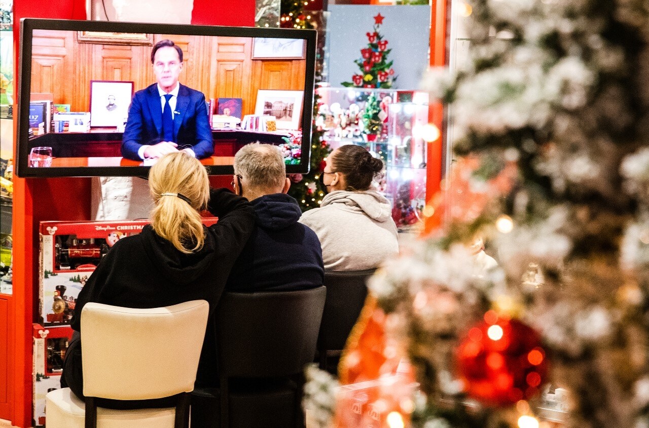 Premier Rutte live vanuit het Torentje, ondernemers tv-kijkend vanuit hun winkel. Ook zij horen: de lockdown is een feit. Foto: ANP.