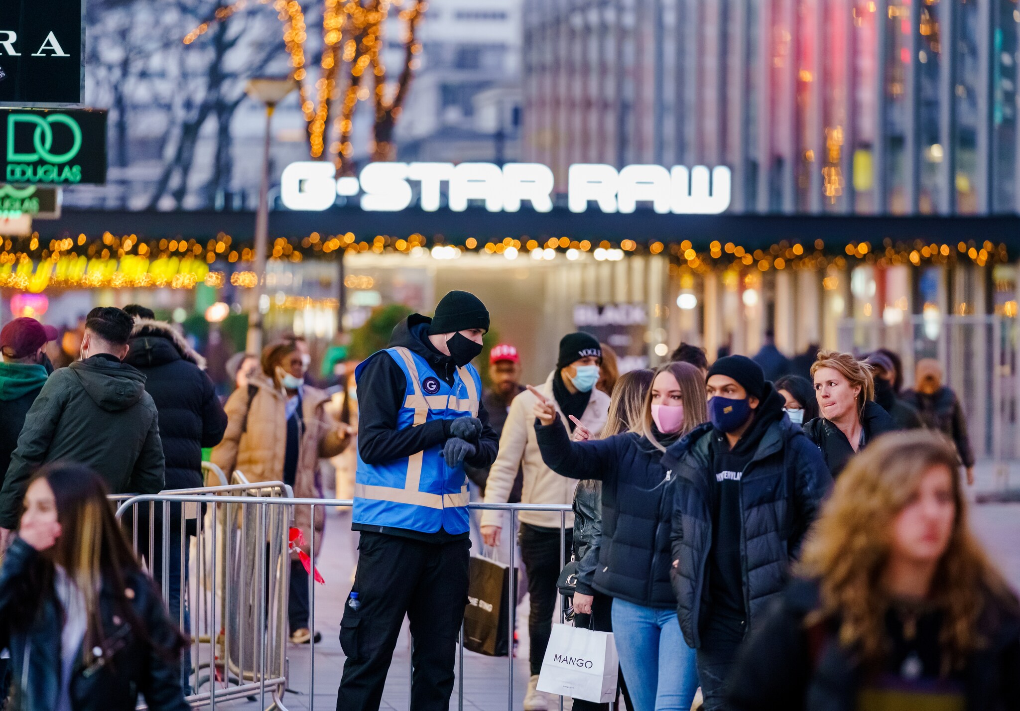 Beveiligers wijzen mensen op het eenrichtingsverkeer in de Lijnbaan op de drukke koopzondag in Rotterdam van afgelopen weekend. Foto: ANP