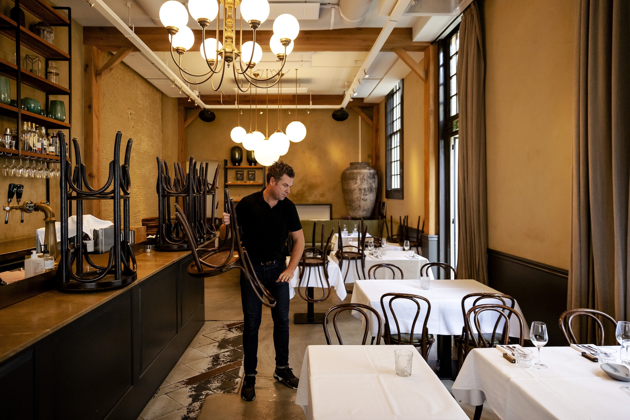 Voorbereidingen in een leeg restaurant in Breda vlak voor openingstijd, een dag nadat het kabinet nieuwe coronamaatregelen voor de horeca aankondigde. Foto: ANP