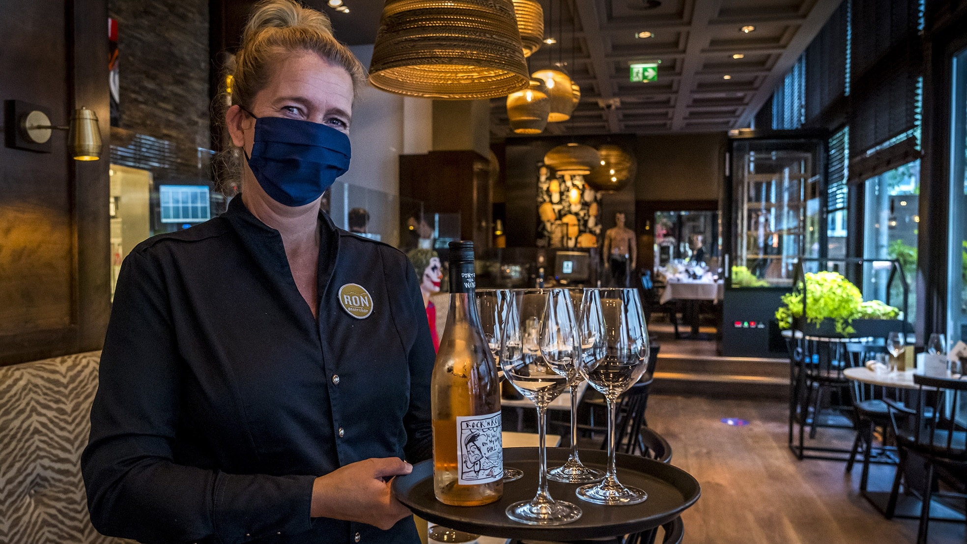 Een bedieningsmedewerkster van Ron Gastrobar, mét mondkapje. Foto: ANP