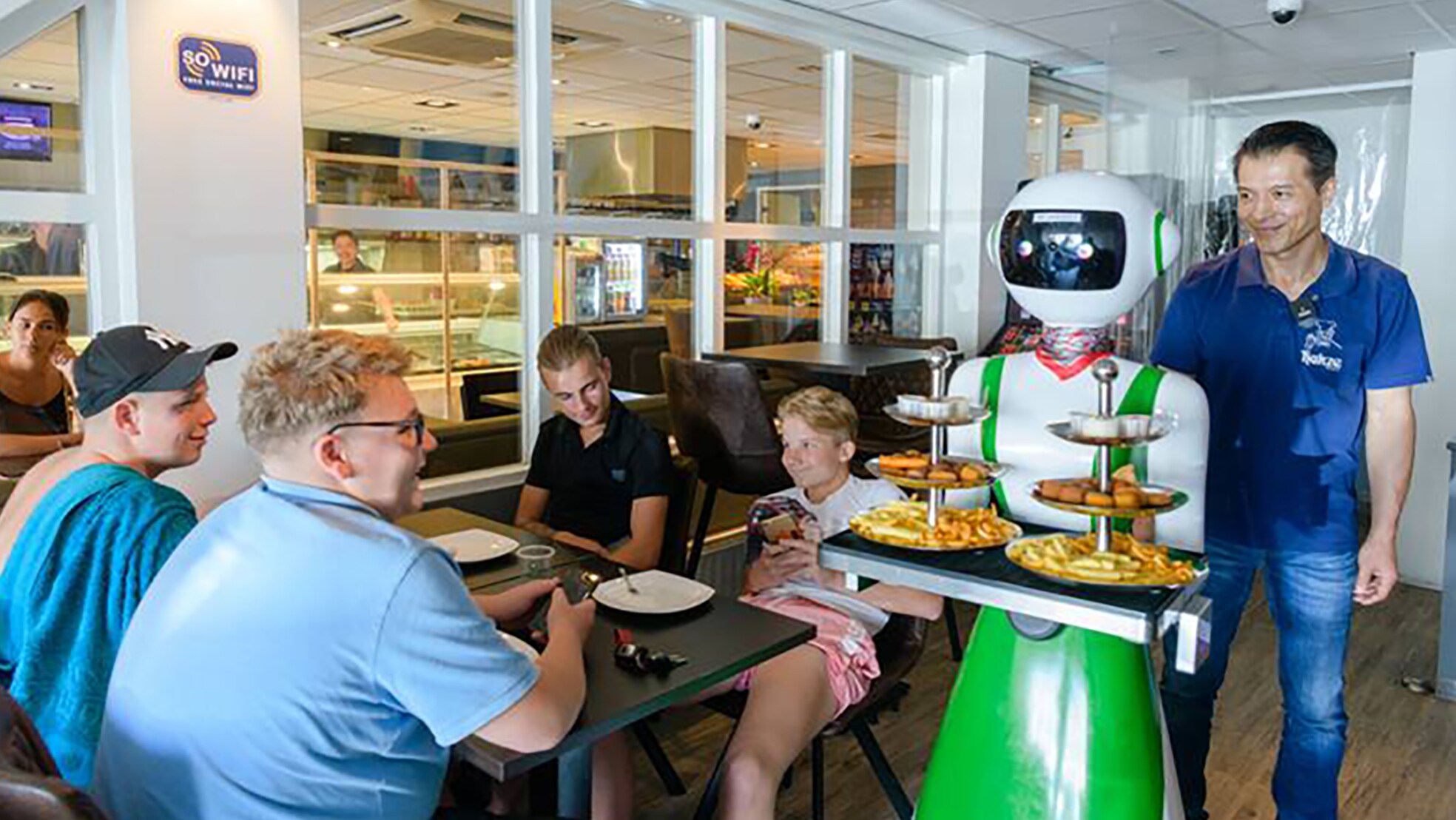Alexa bedient de gasten in cafetaria Hakze. Rechts kijkt eigenaar Michael Hu toe. Foto Mel Boas