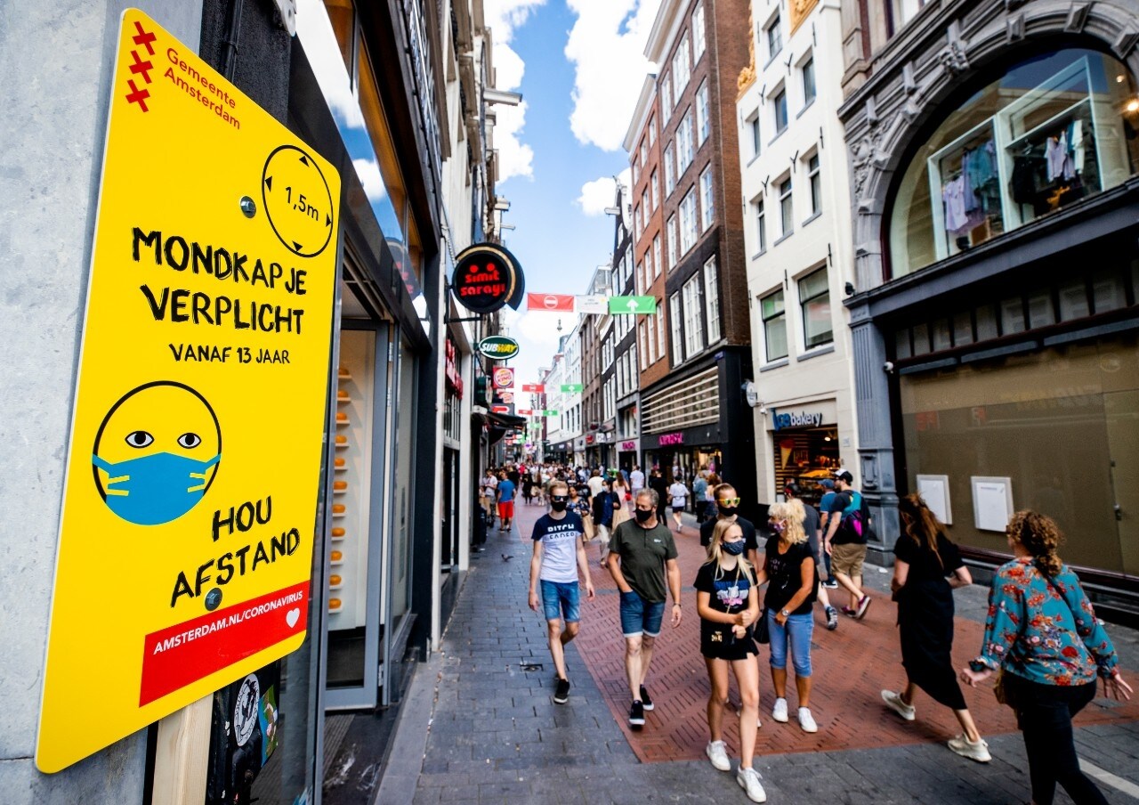 Een van de vele borden met informatie over mondkapjesplicht op de Nieuwendijk in Amsterdam. Foto: ANP.