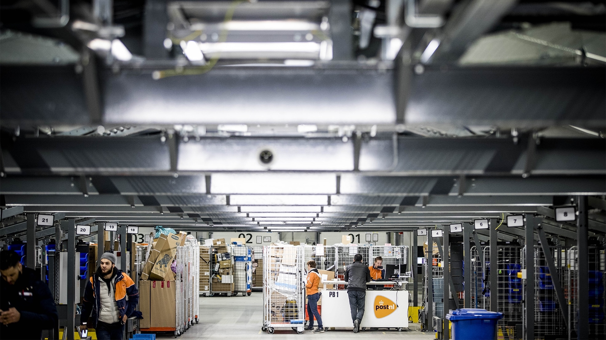 Medewerkers van PostNL sorteren online aangeschafte pakketjes in het sorteercentrum. Foto: ANP