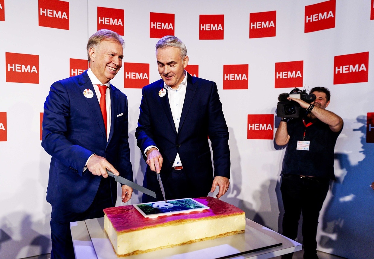 Marcel Boekhoorn snijdt bij de overname van de winkelketen de welbekende taart aan met Hema-ceo Tjeerd Jegen.
