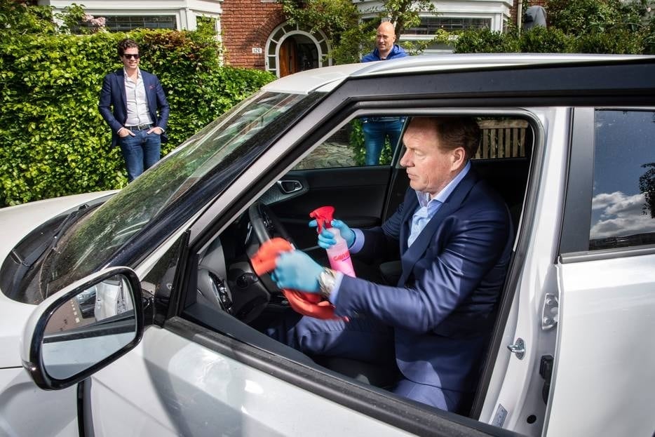 Autodealer Frank Vaneman reinigt een auto voordat een potentiële klant er een proefrit mee gaat maken. Foto: Marco Okhuizen