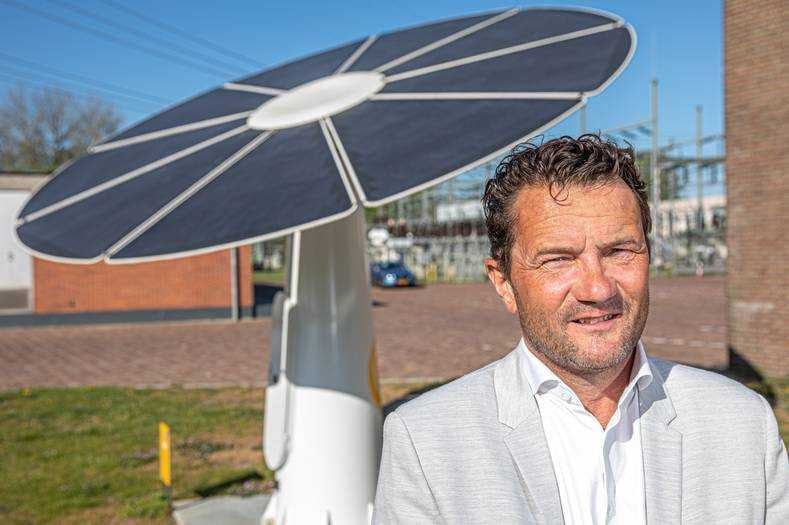Hans Veenemans en een van zijn Zwolse zonnebloemen. ,,Het Provinciehuis in Zwolle ligt vol met zonnepanelen, heel goed ja, maar dat ziet niemand. Om mijn bloemen kun je niet heen. Die raken je.” Foto: Frans Paalman.