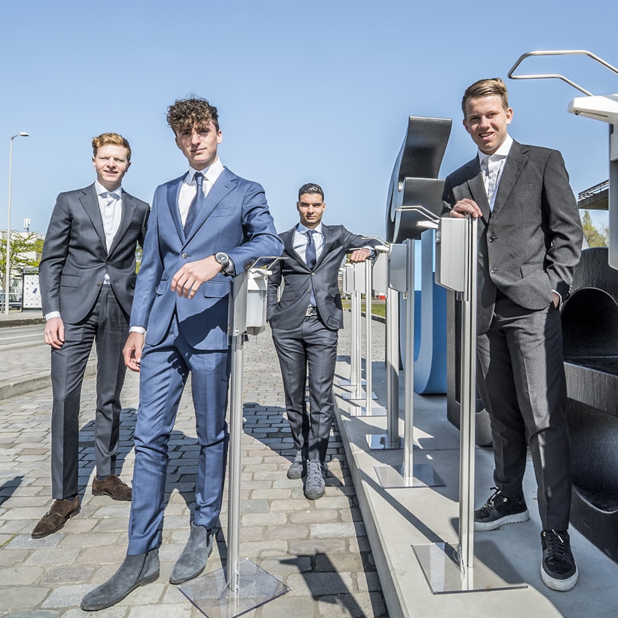 jonge ondernemers achter handdesinfectiezuilen met elleboogdispenser