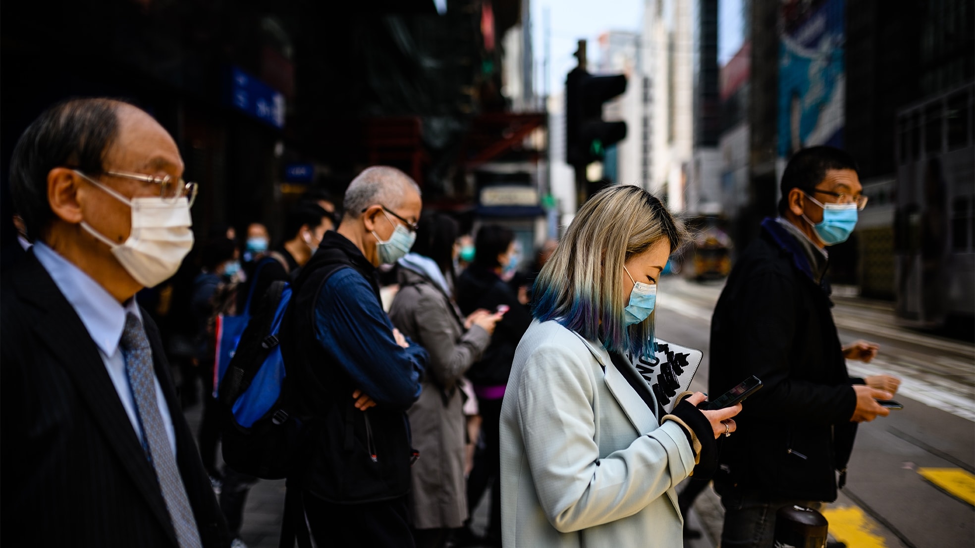 Voetgangers in Hong Kong beschermen zichzelf met mondkapjes tegen het coronavirus. Foto: Anthony Wallace/AFP