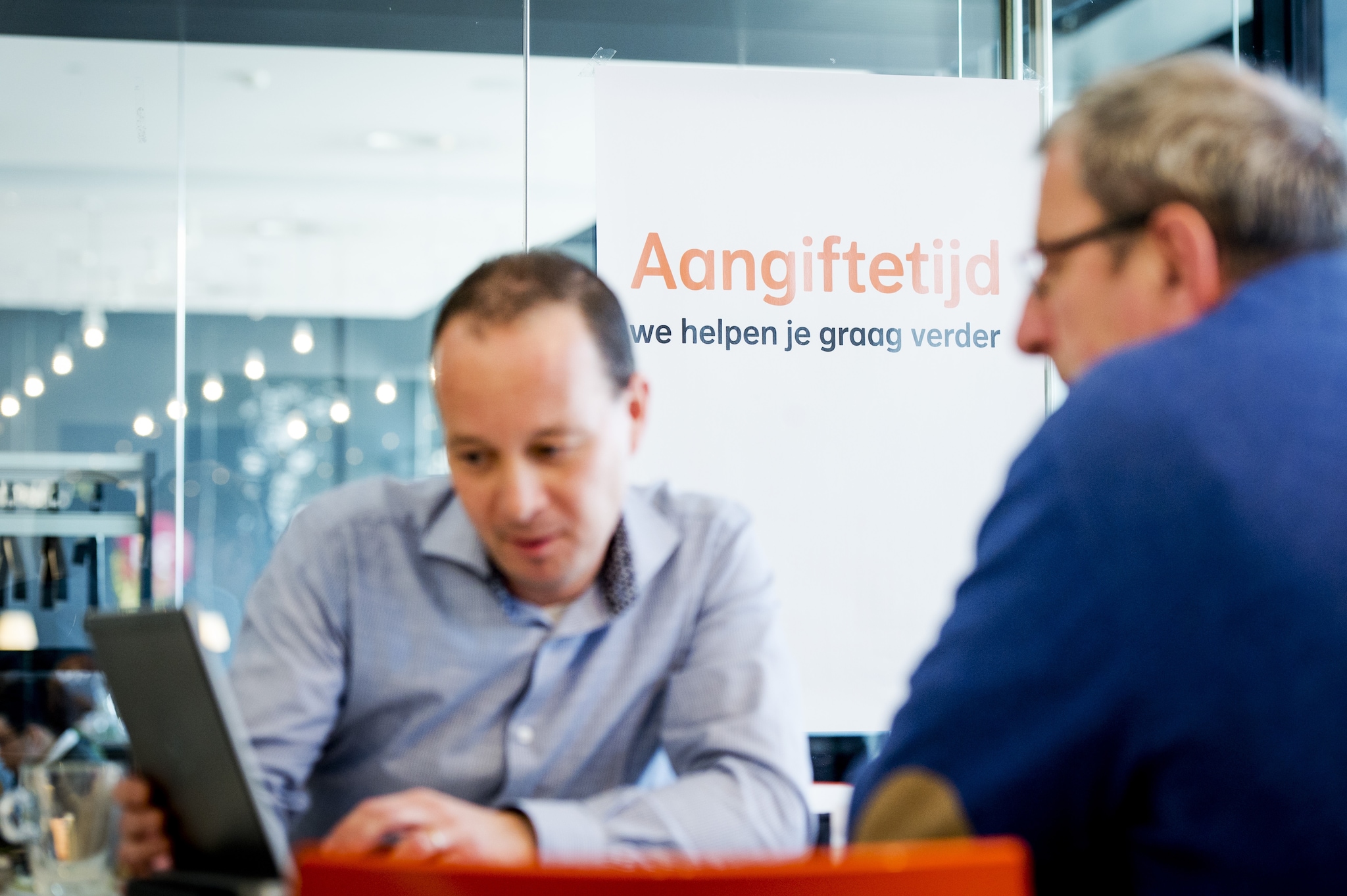 Een medewerker van Nationale-Nederlanden helpt een belastingplichtige bij het invullen van zijn aangifte. Foto ter illustratie. Credit: ANP/Robin van Lonkhuijsen.