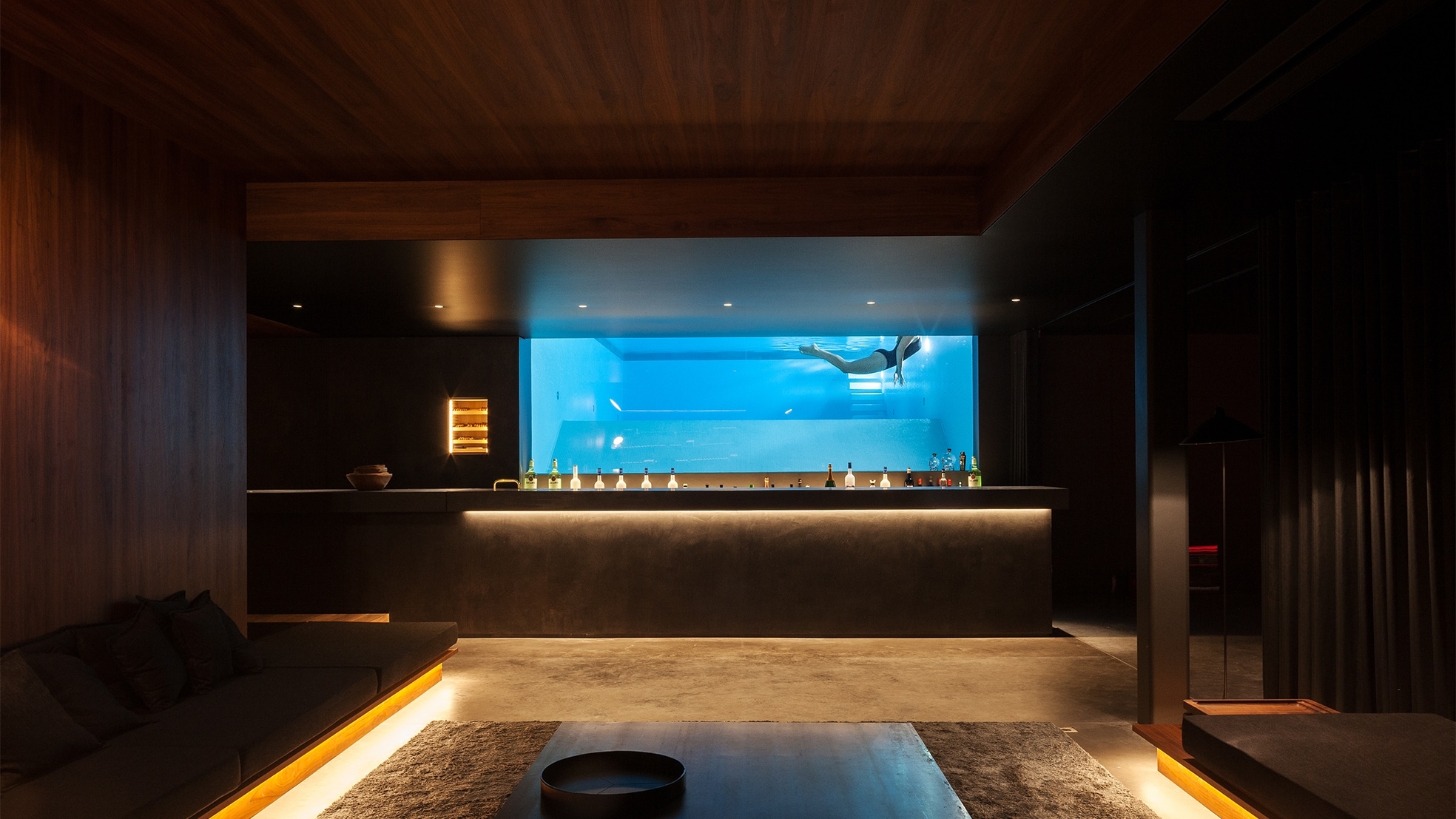 Mancave in een privéwoning in België achter de bar een doorkijk naar het zwembad (Foto: Tim Van de Velde). Onder: Mark Hoentjen, directeur/eigenaar van Underwaterwindows (Foto: Patrick van Gemert/Zutphens Persbureau). Daaronder: spectaculair zwembad in Spanje (Foto: Underwaterwindows).