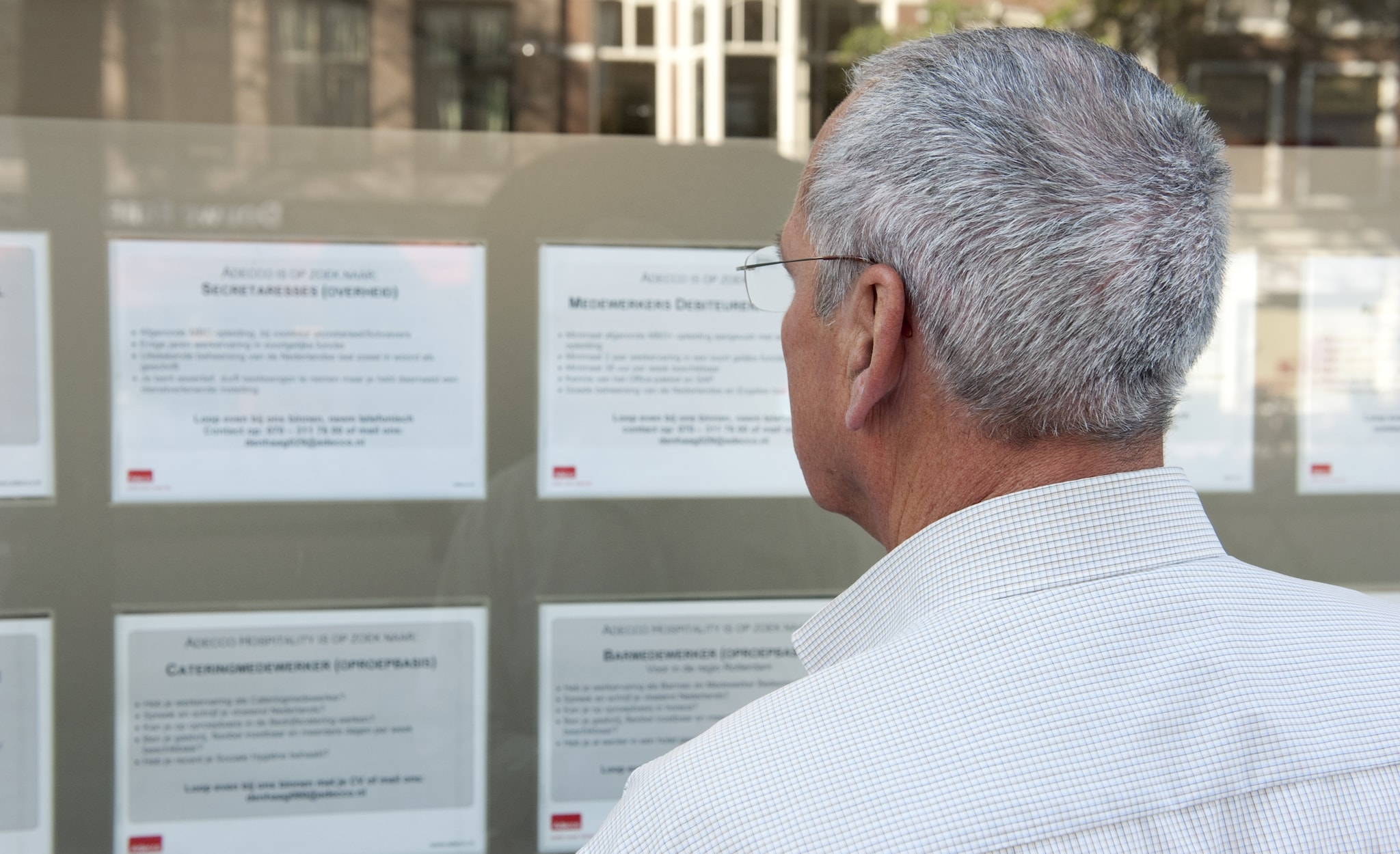 Een oudere man bekijkt vacatures bij een uitzendbureau. Foto: ANP