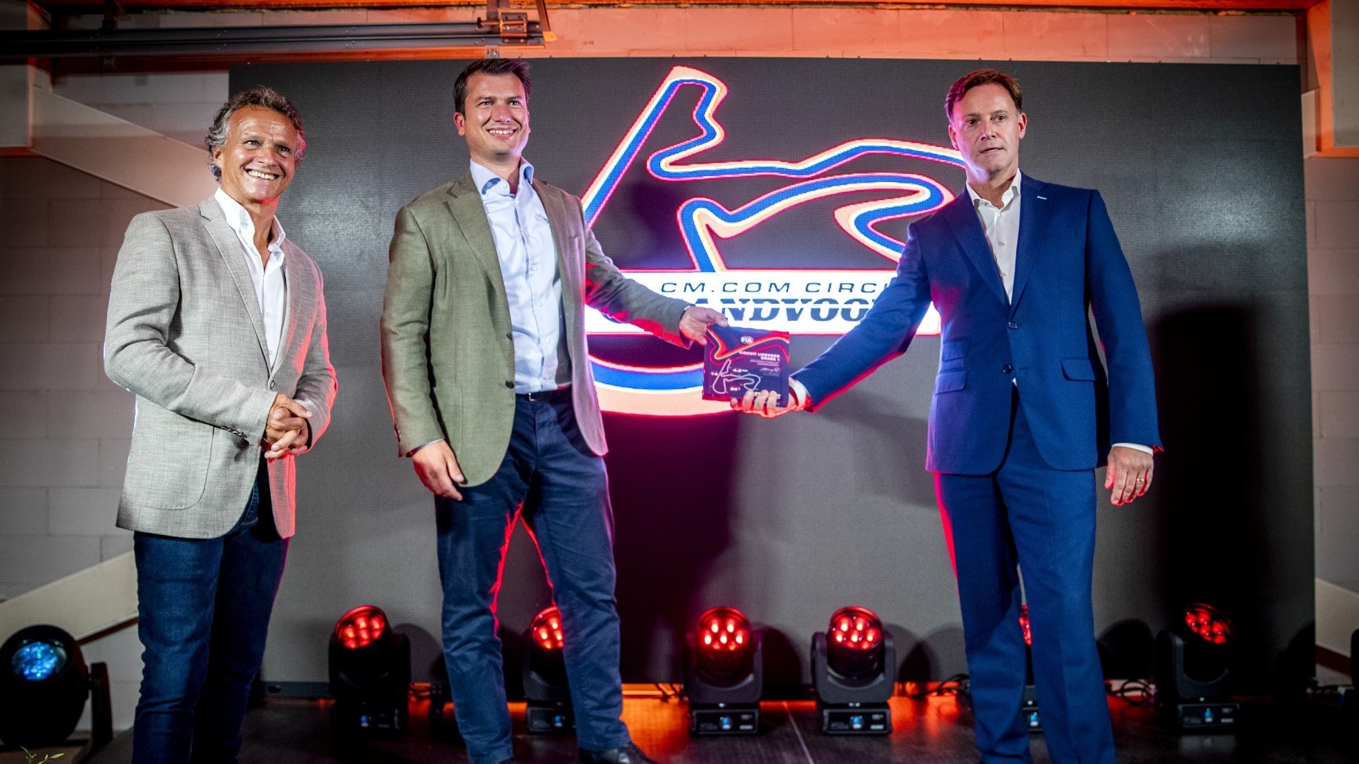 Jeroen van Glabbeek (midden), ceo van CM.com, zette vorig jaar zijn handtekening onder een sponsordeal met Circuit Zandvoort. Jan Lammers (links), sportief directeur Dutch Grand Prix, en Robert van Overdijk, directeur Dutch Grand Prix, waren ook aanwezig. Foto: ANP