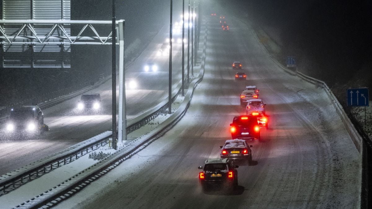 Verkeer rijdt over een met sneeuw bedekte snelweg A76 bij Heerlen. ANP