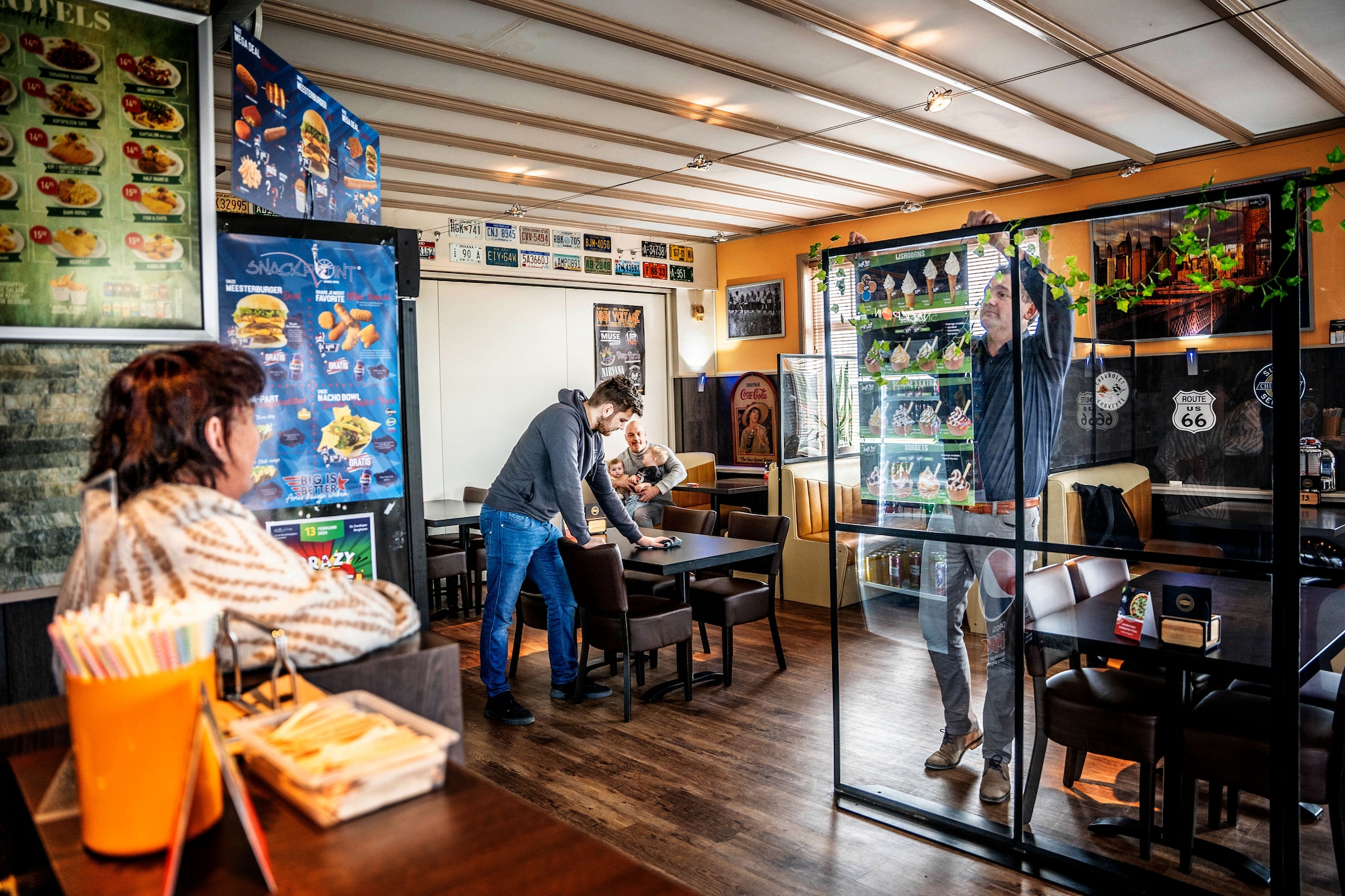 Hannie (l) kijkt toe hoe vader Marco en zoon Luc Geurds de tafels aan het verschuiven zijn in haar voormalige cafetaria. Op de achtergrond Henry met zijn kleinkinderen. Eveline van ELK