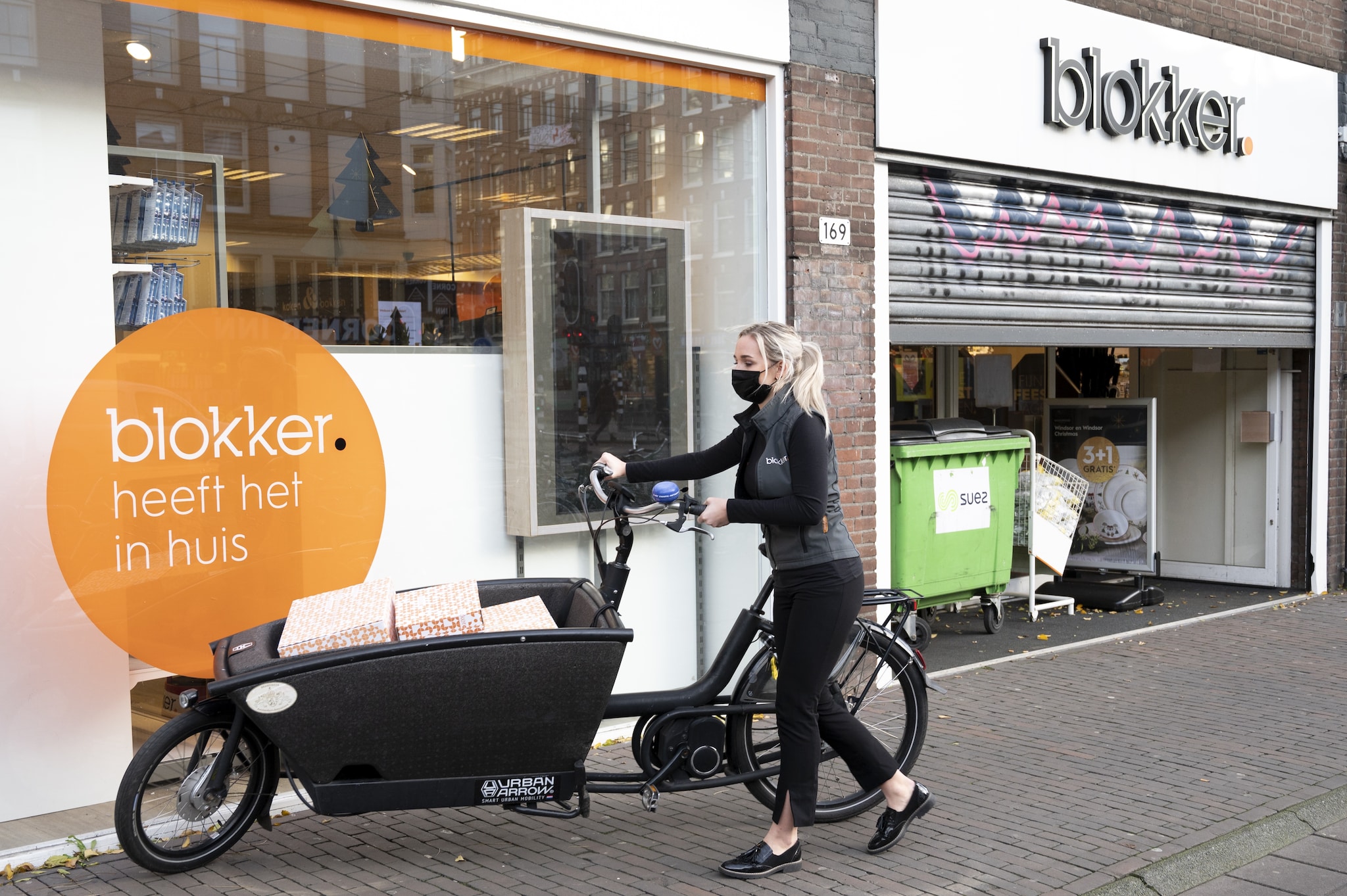 Een medewerker van de Blokker vertrekt met pakketjes richting een klant. ANP