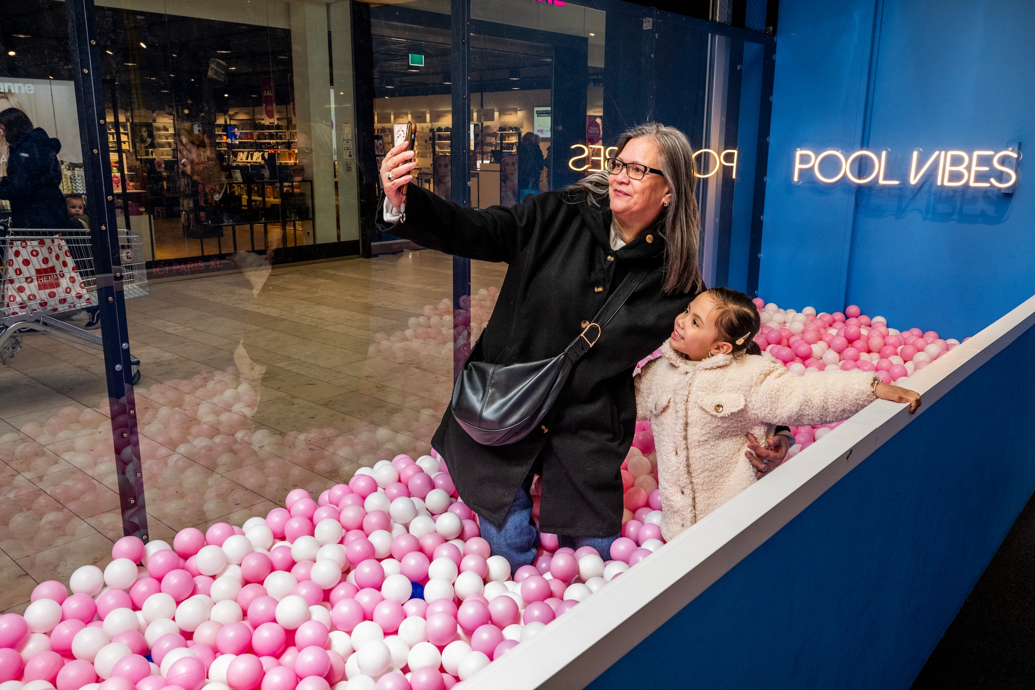 Meity Kraay en kleindochter Shazoah maken een selfie in het roze ballenbad Frank de Roo