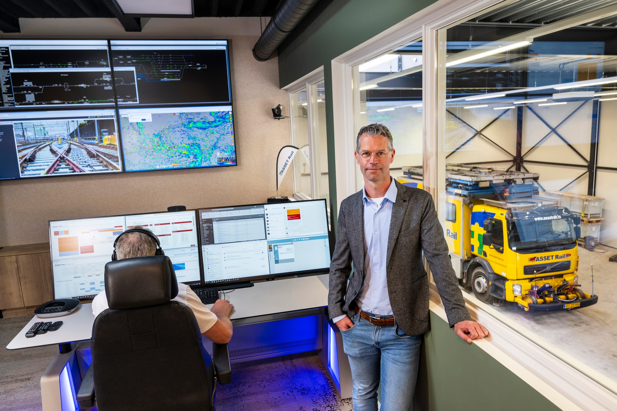 Algemeen directeur Jorn Pruntel in de fonkelnieuwe ruimte van de landelijke storingsdienst in het kantoor in Bemmel. Rechts de loods die volledig was afgebrand. Gerard Burgers