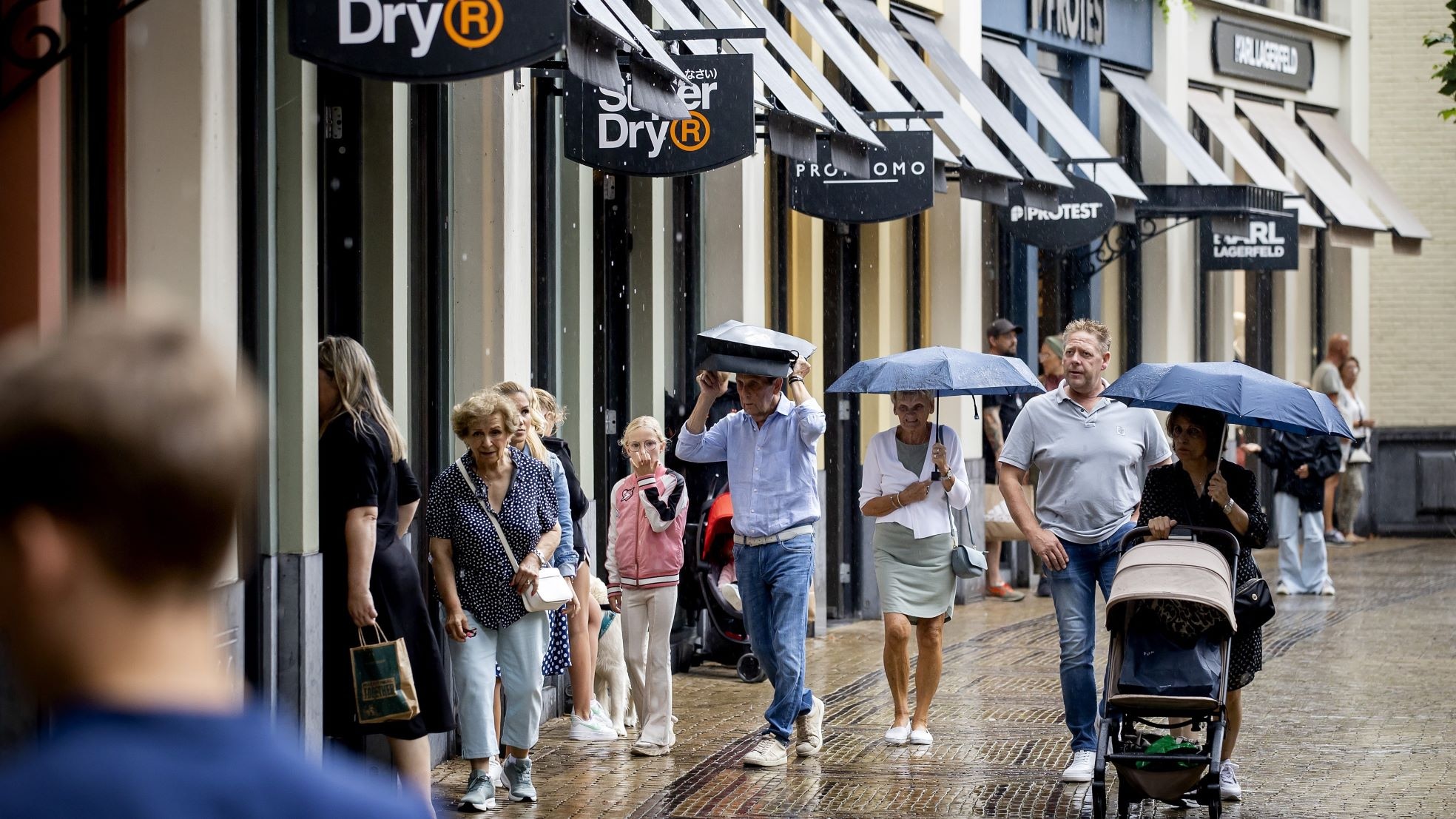 Een dagje shoppen in een regenachtig Batavia Stad. Foto: ANP Een dagje shoppen in een regenachtig Batavia Stad. Foto: ANP