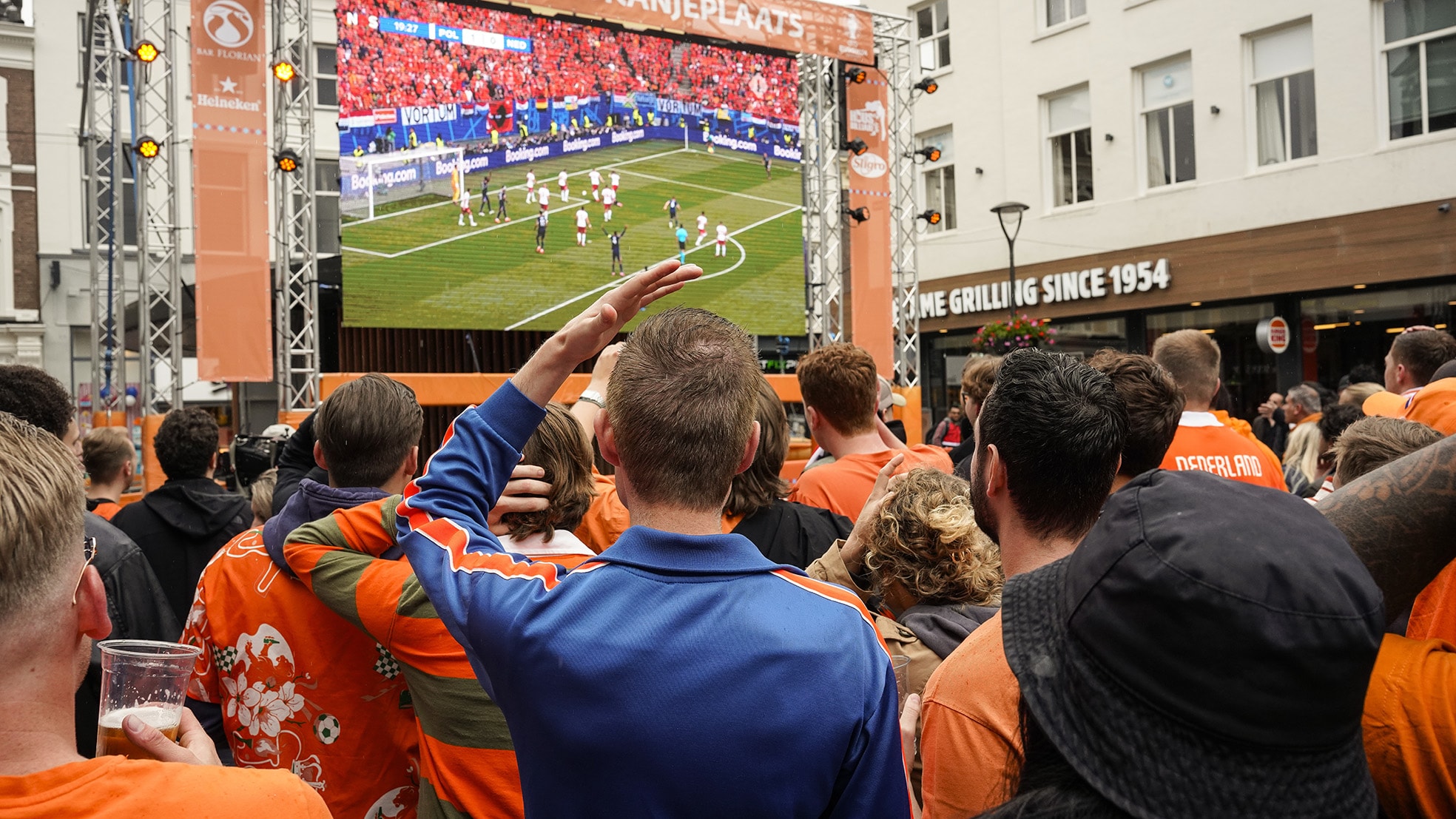 Een menigte Oranjefans bekijkt op het Jansplein in Arnhem op een groot scherm de eerste WK wedstrijd van het Nederlands Elftal tegen Polen. Foto: ANP/Hollandse Hoogte/Bert Spiertz Een menigte Oranjefans bekijkt op het Jansplein in Arnhem op een groot scherm de eerste WK wedstrijd van het Nederlands Elftal tegen Polen. Foto: ANP/Hollandse Hoogte/Bert Spiertz