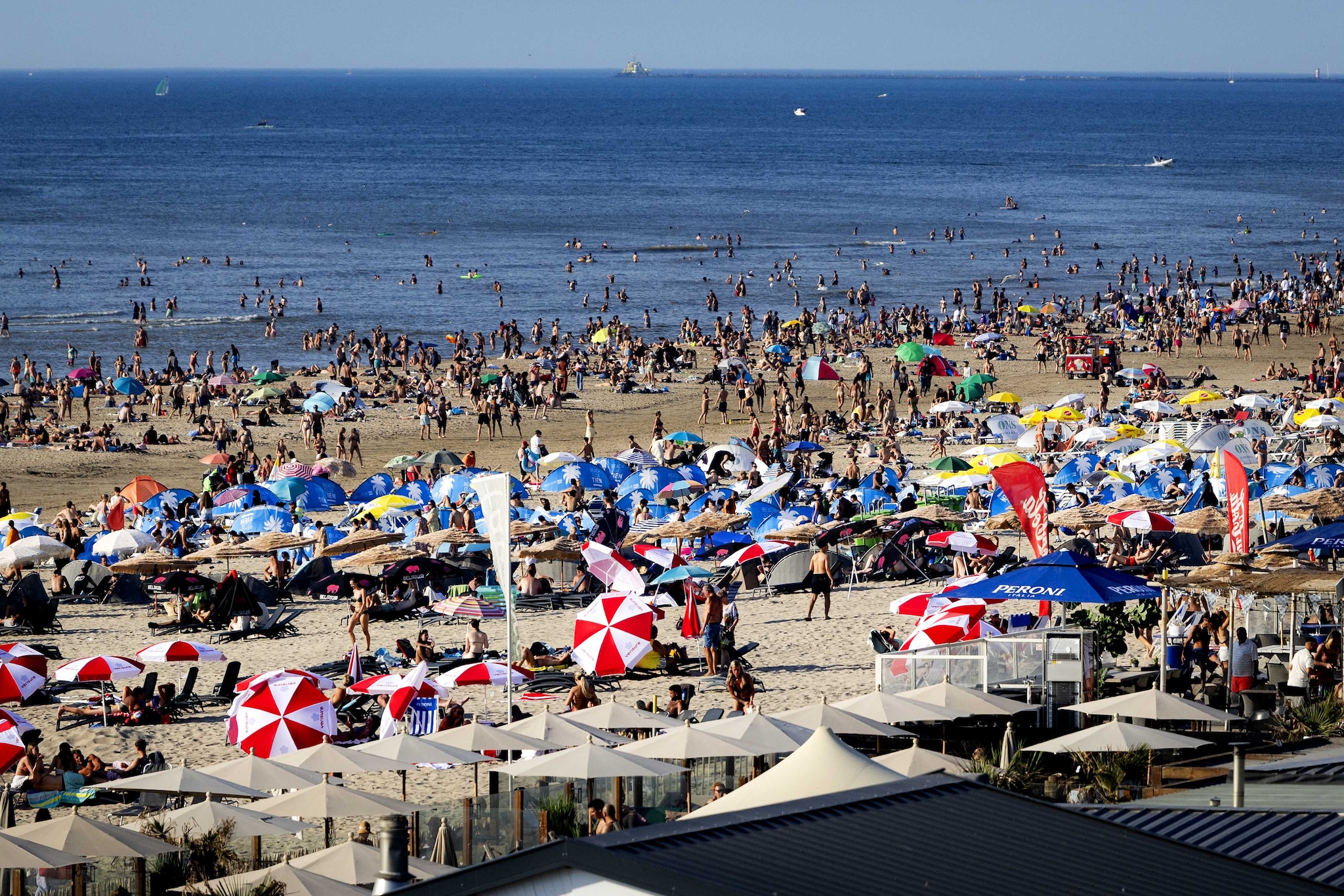 Drukte op het strand bij badplaats Zandvoort. Vanwege het warme zomerweer is het druk aan de kust. Beeld: ANP Ramon van Flymen ANP. Drukte op het strand bij badplaats Zandvoort. Vanwege het warme zomerweer is het druk aan de kust.