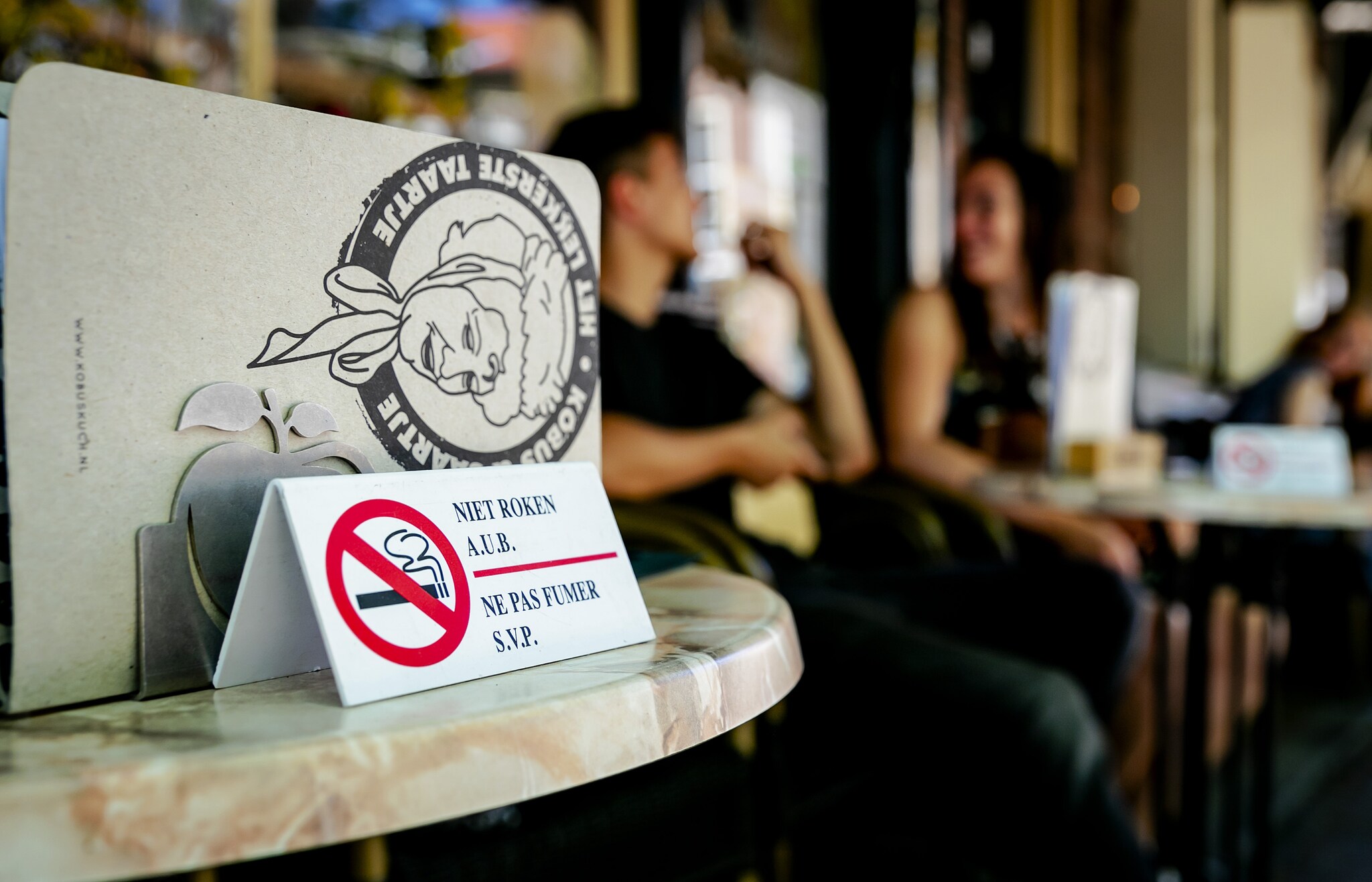 Een bordje verzoekt mensen niet te roken, op een gedeeltelijk rookvrije terras. Steeds meer horeca stappen over op een rookvrij terras. Foto: ANP