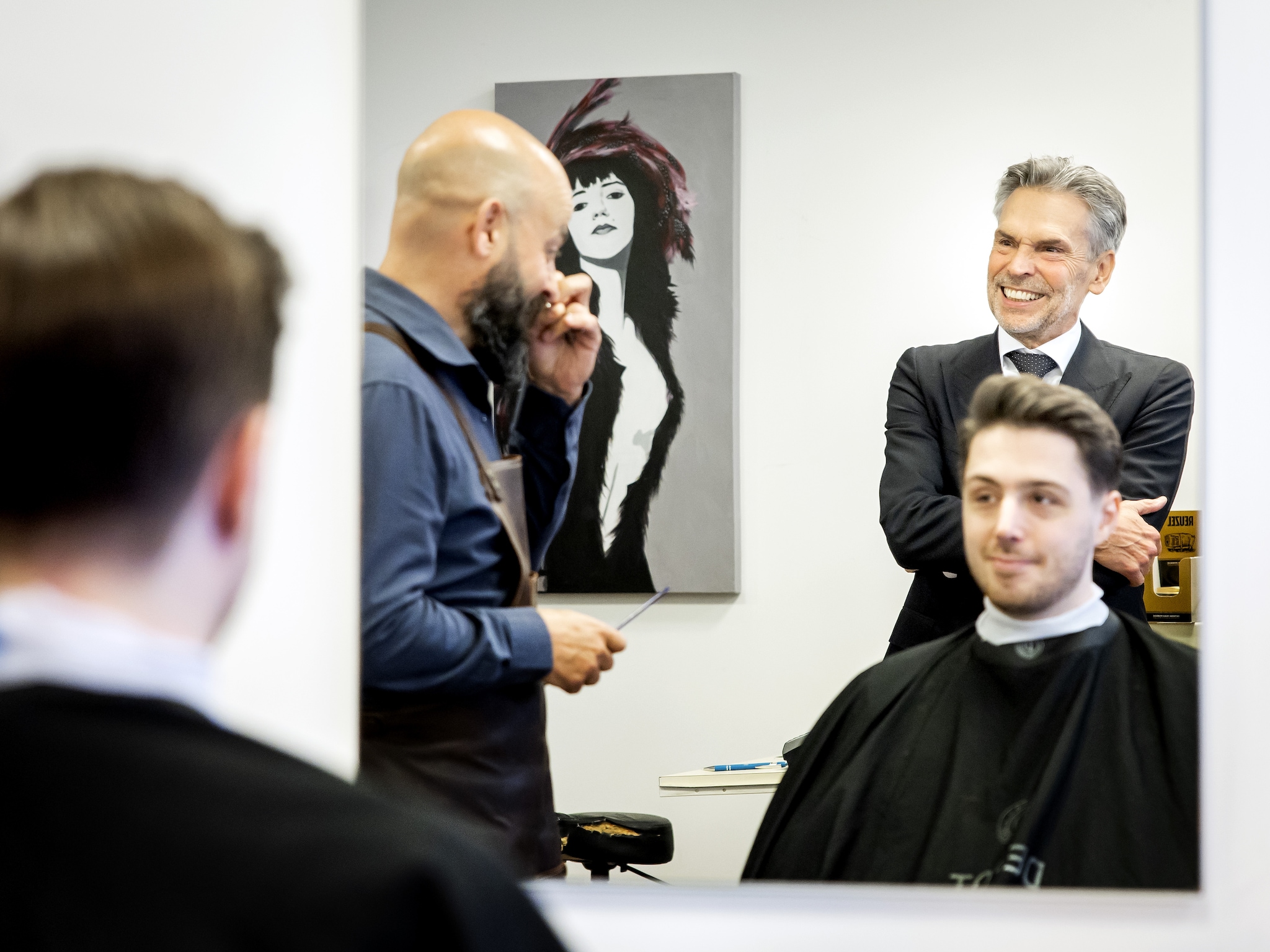 Dick Schoof bezoekt De Barbier in de Jan de Bakkerstraat. Eigenaar Arno van den Bergh is op dat moment gewoon bezig met een klant, die een strakke coupe aangemeten krijgt. ANP