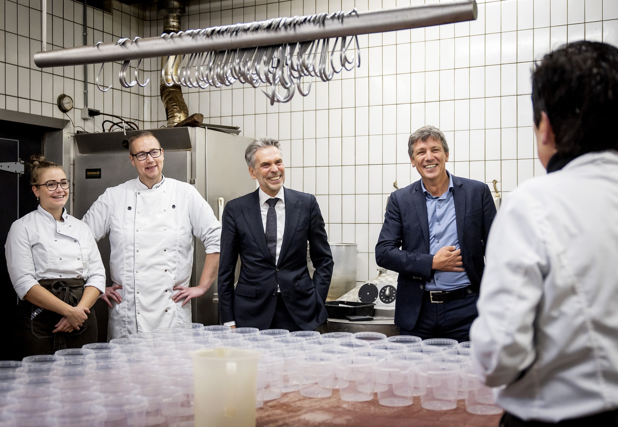 Gineke van Kesteren (vanaf de rug) vertelt enthousiast over haar slagerij. Links de opvolgers, in het midden Dick Schoof en rechts Jacco Vonhof. Gineke van Kesteren (vanaf de rug) vertelt enthousiast over haar slagerij. Links de opvolgers, in het midden Dick Schoof en rechts Jacco Vonhof. Foto: ANP
