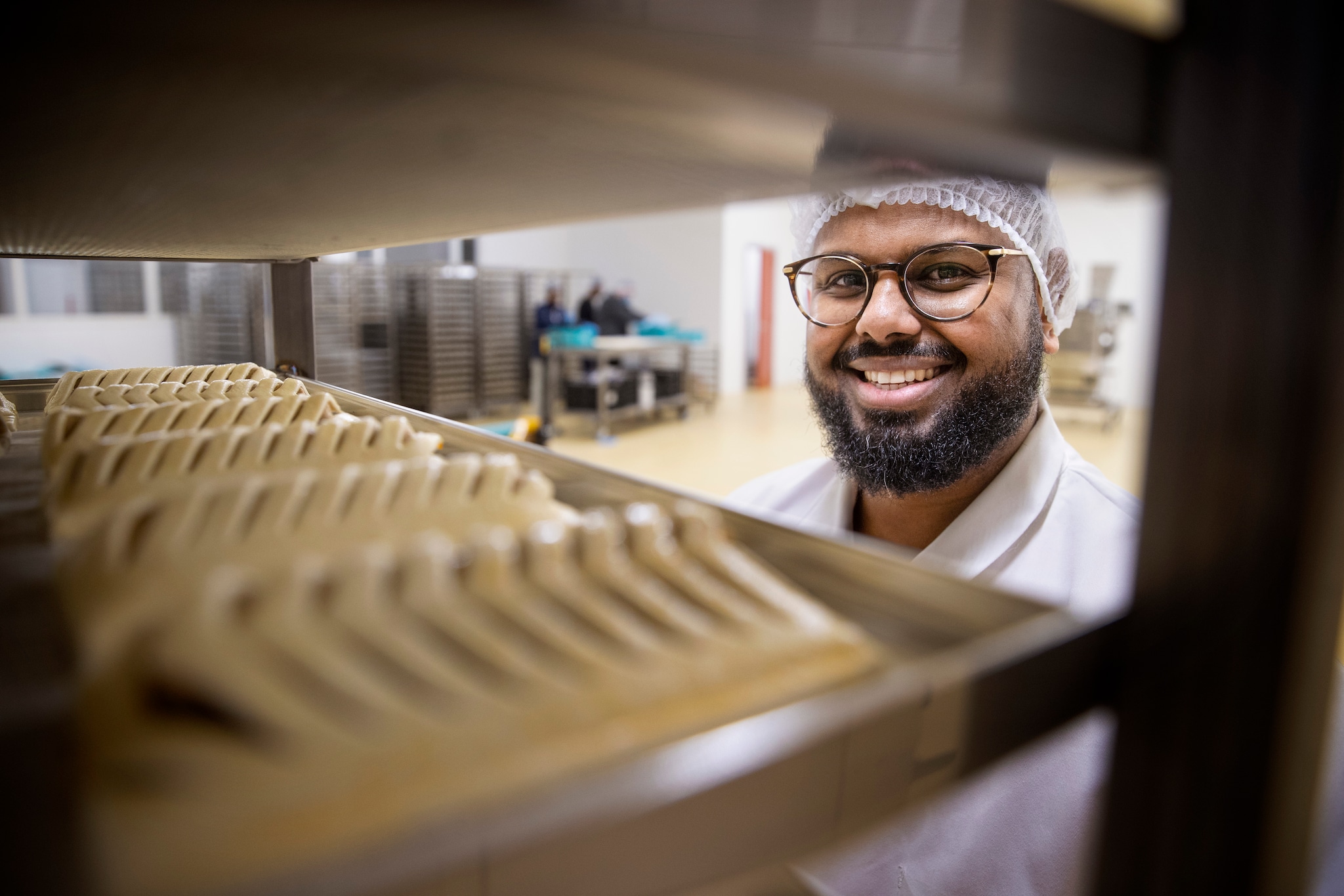 Kadir Ahmed bij een oven vol frikandellenbroodjes. Kadir Ahmed bij een oven vol frikandellenbroodjes. Foto: René Manders/DCI Media