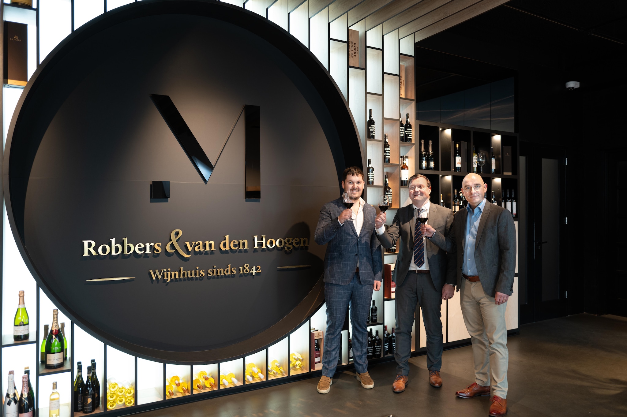 Adrian Kreter, Marcel Donders en Pierre Hoogesteger (van links naar rechts) proosten op de overname van Wijnhuis Robbers &amp; van den Hoogen aan de Velperweg in Arnhem. Adrian Kreter, Marcel Donders en Pierre Hoogesteger (van links naar rechts) proosten op de overname van Wijnhuis Robbers &amp; van den Hoogen aan de Velperweg in Arnhem. Foto: Robberts &amp; van den Hoogen/PR