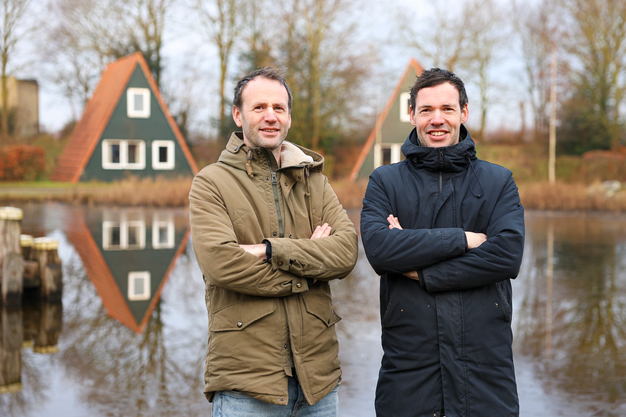Han (links) en Wietze van Wegen bij de puntdakhuisjes van hun vakantiepark bij Bant. ,,Een iconische onderdeel van Eigen Wijze.’’ Jeffrey Korte
