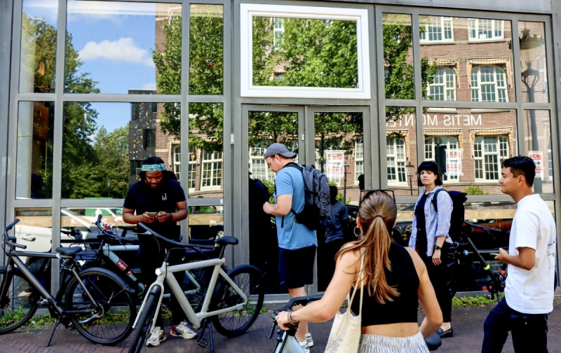 Mensen wachten voor een gesloten VanMoof fietsenwinkel aan de Mauritskade. Klanten wachtend in 2023 tevergeefs voor een gesloten VanMoof fietsenwinkel in Amsterdam Foto: ANP