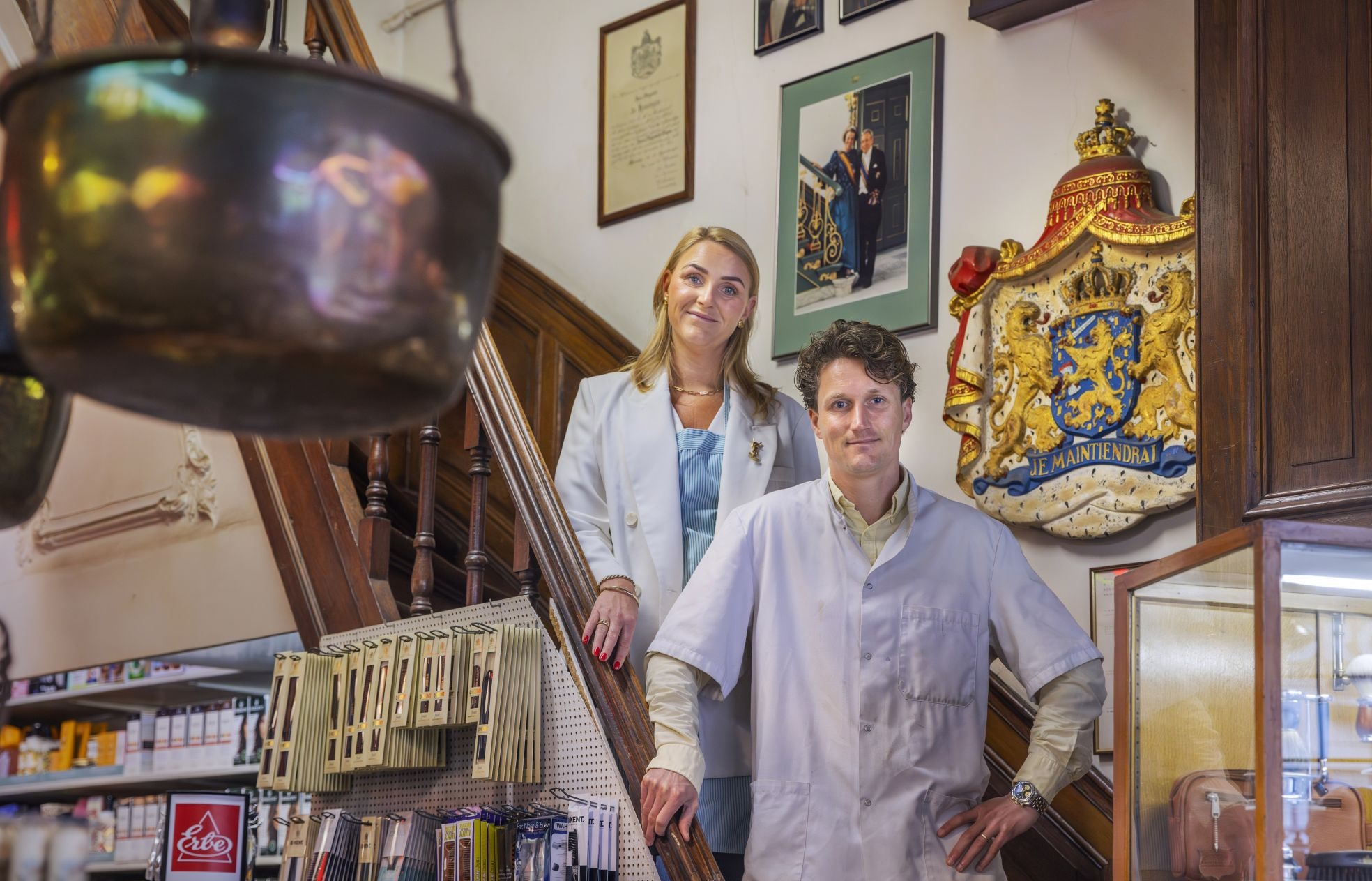 Tom en Esther met achter hen het wapen van het Predicaat Hofleverancier. Tom en Esther met achter hen het wapen van het Predicaat Hofleverancier. Foto: Frank Jansen