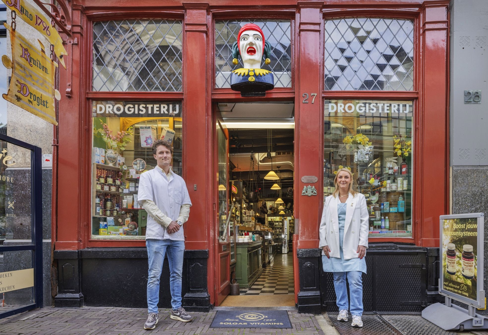 Tom en Esther voor hun drogisterij met boven hen de iconische 'gaper'. Tom en Esther voor hun drogisterij met boven hen de iconische ‘gaper’. Foto: Frank Jansen