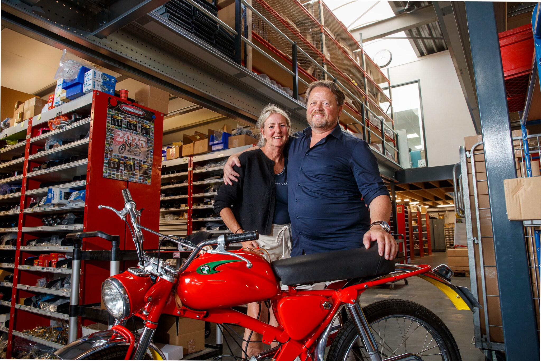 Anneke en Sjoerd van der Zee met een Puch brommer in hun magazijn in Wageningen. Herman Stöver  Anneke en Sjoerd van der Zee met een Puch brommer in hun magazijn in Wageningen. Foto: Herman Stöver
