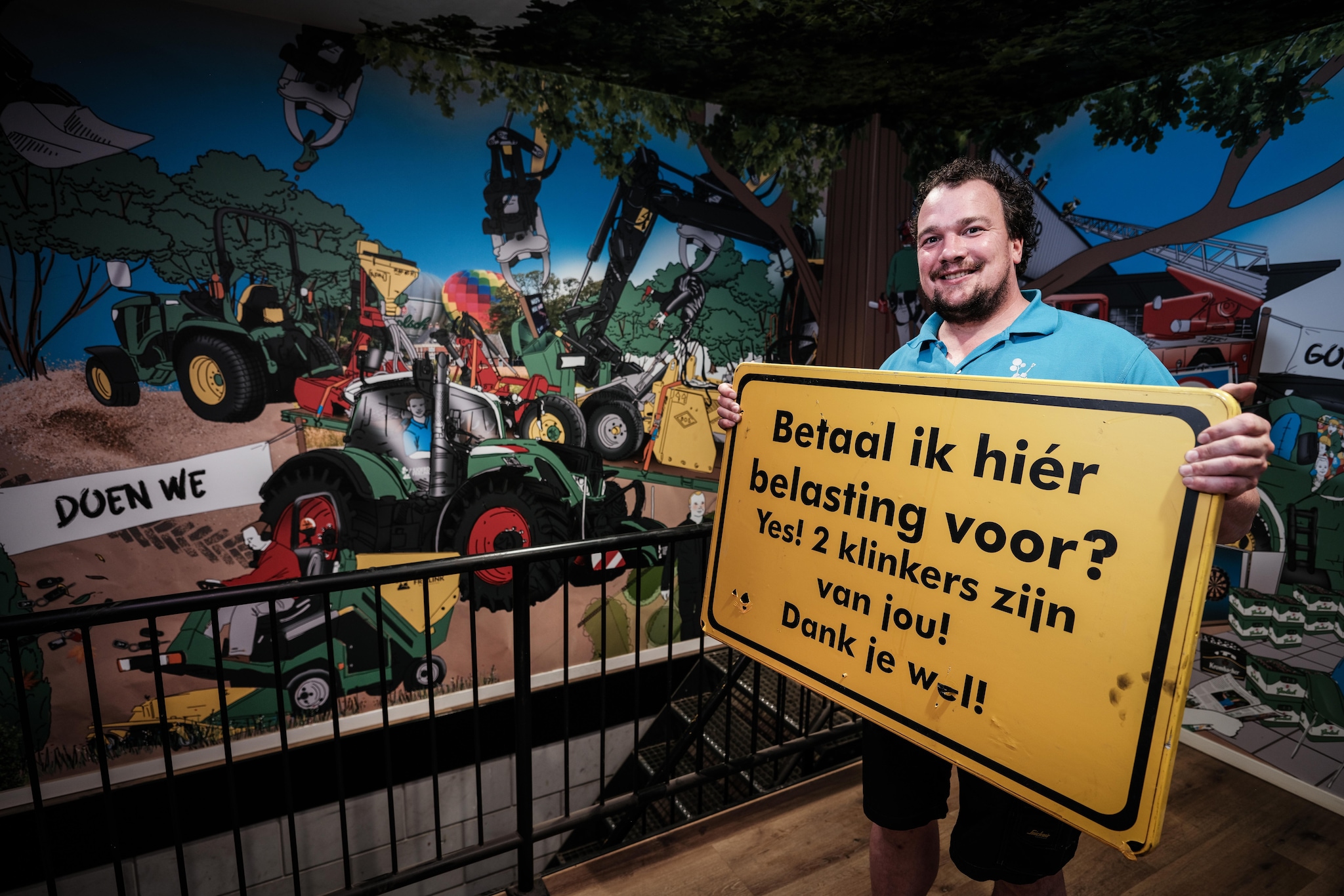 Sjoerd Frielink met een van de ludieke bordjes die werd gebruikt tijdens de herinrichting van de Wooldstraat.  Sjoerd Frielink met een van de ludieke bordjes. Foto: Jan van den Brink