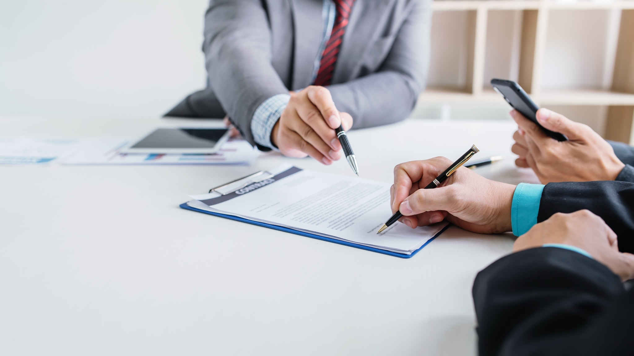 Business people sign financial business contract. Werkgeversaansprakelijkheid, hoe ver gaat dat? Foto: Shutterstock/Amnaj Khetsamtip.