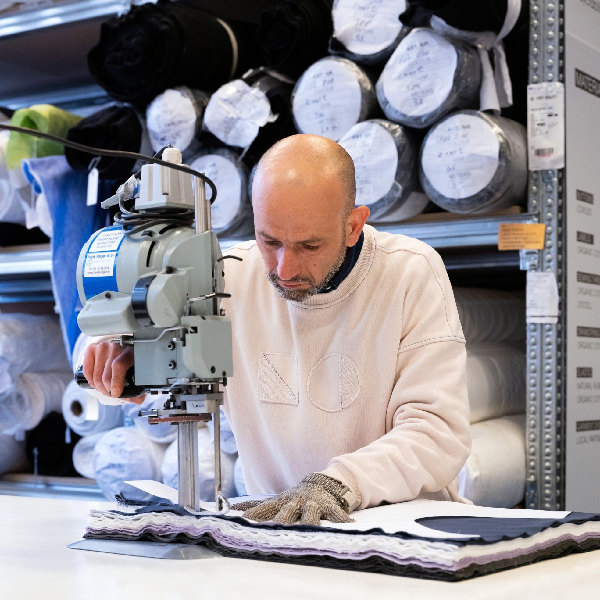Een medewerker van New Optimist in het atelier van het kledingmerk. Een medewerker van New Optimist in het atelier van het kledingmerk. Foto: Titia Hahne