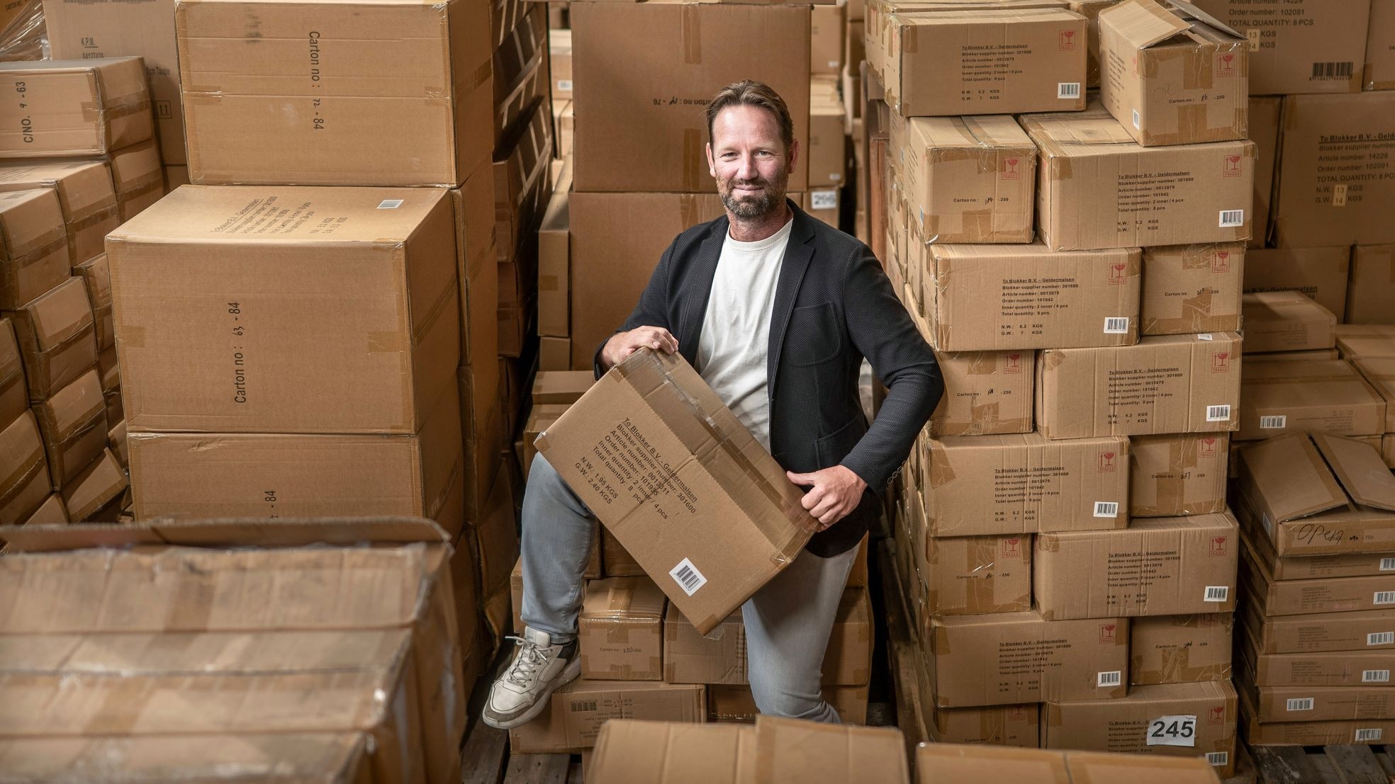 Eric Kooistra tussen duizenden dozen aan Blokkerspullen. Eric Kooistra tussen duizenden dozen aan Blokkerspullen. Foto: Corné Sparidaens