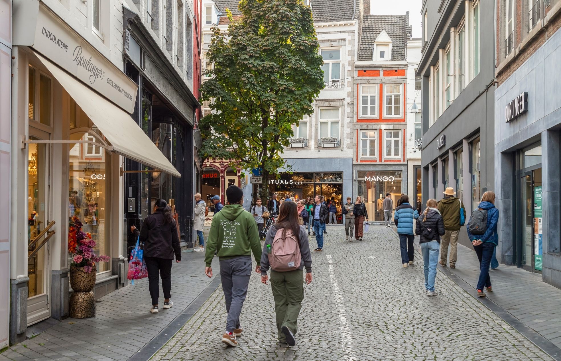 Passanten in een winkelstraat in Maastricht. Passanten in een winkelstraat in Maastricht. Foto: Shutterstock