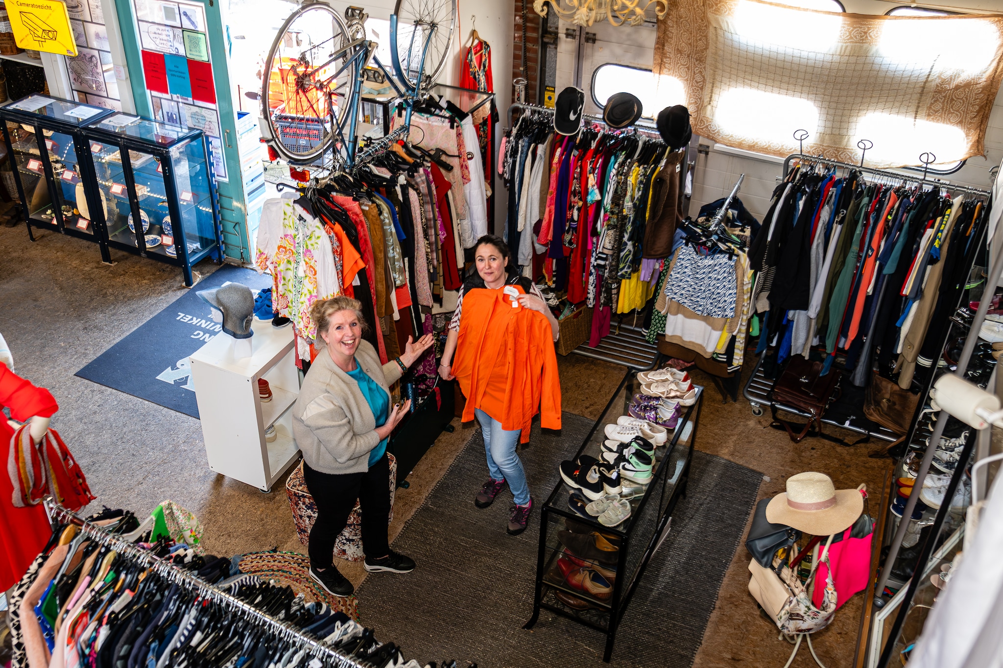 Seizoensgebonden spullen, zoals oranje kleding voor Koningsdag, worden in de rekken gehangen. Foto: Mel Boas