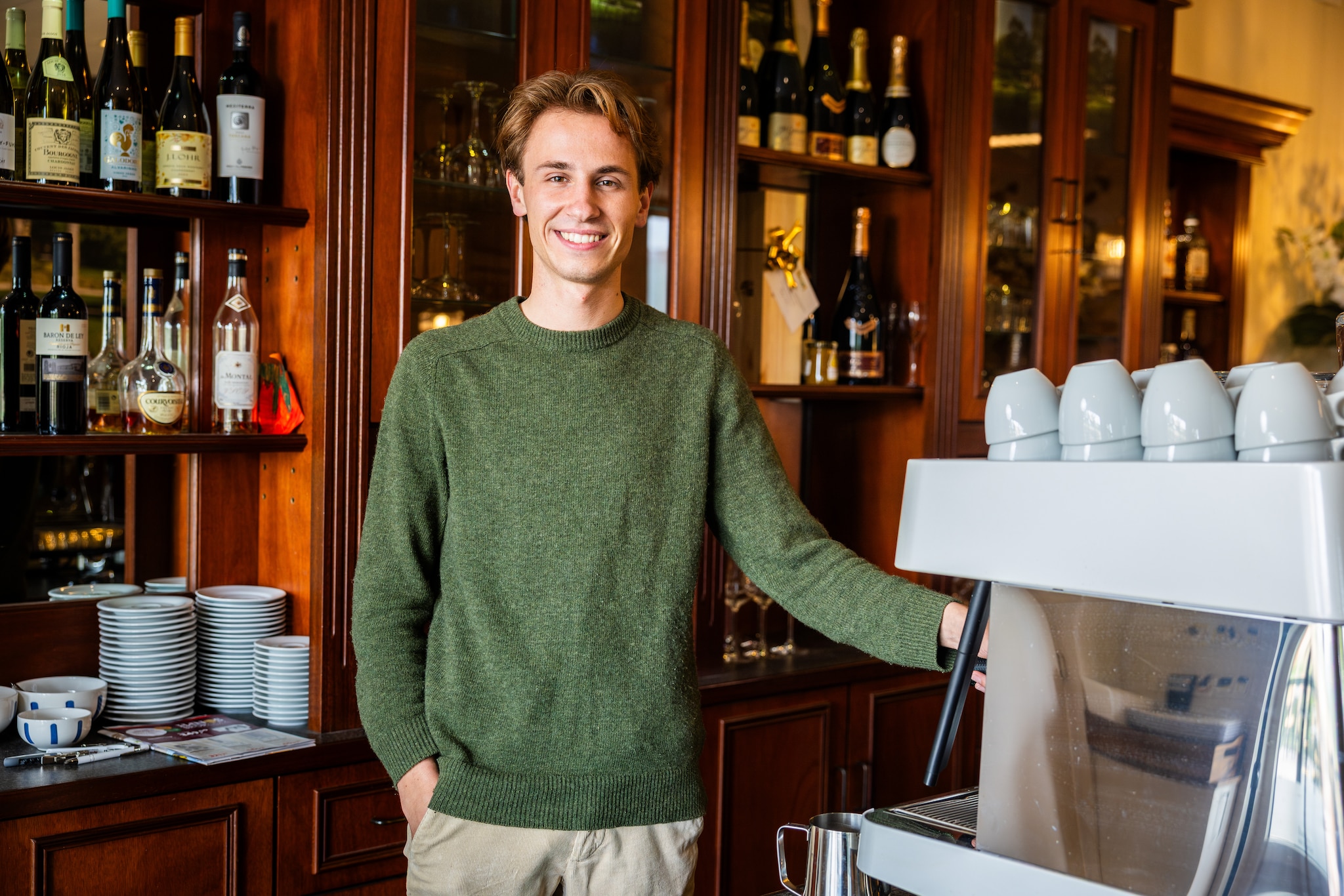 Thomas Tigelaar staat trots achter zijn gloednieuwe koffiemachine.