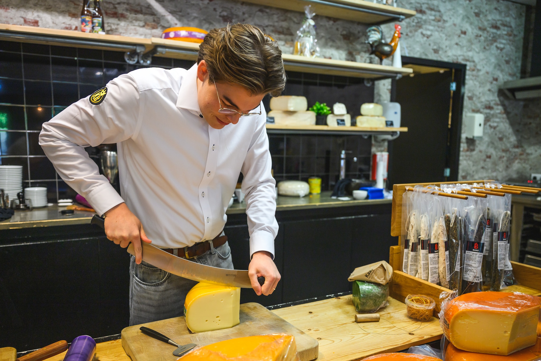 Dirjan snijdt een kaas aan. Foto: Stefan Roelfsema