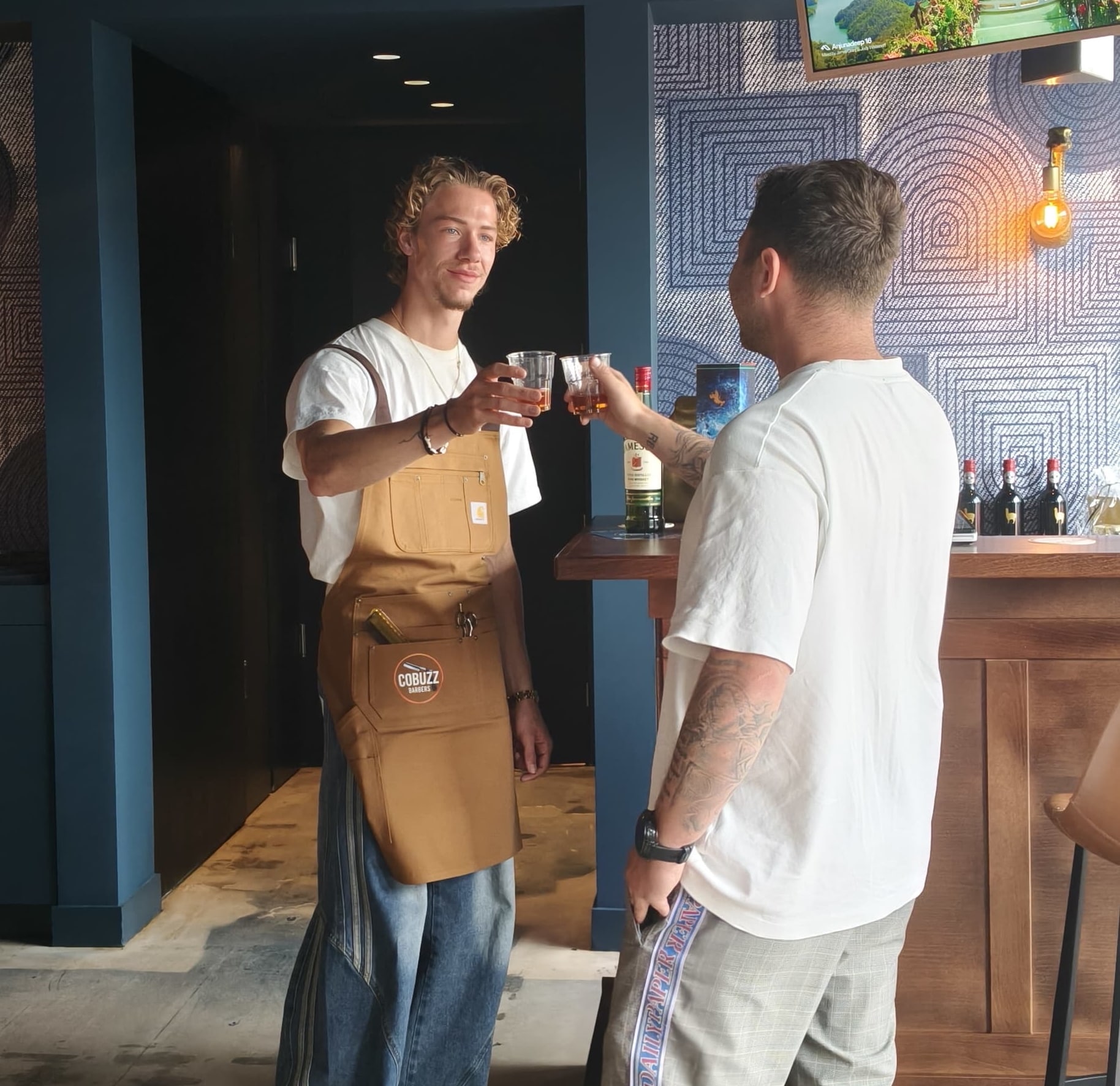 Barber Mats van Es (l) in het net geopende Cobuzz Barbers. Cobuzz Barbers