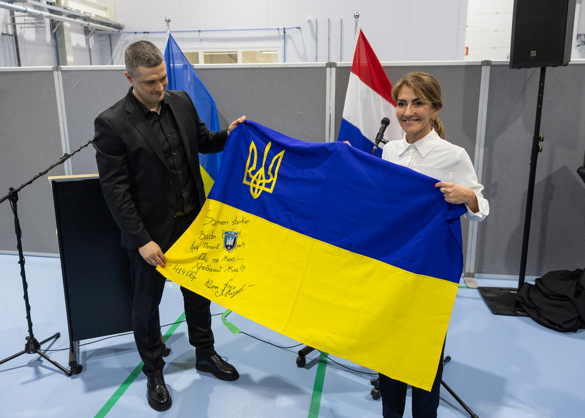 Oud-defensieminister Mykhailo Fedorov schenkt zijn Nederlandse collega Dilan Yesilgöz een vlag met teksten van de gevreesde Oekraïnse dronebrigade. Foto: Destinus