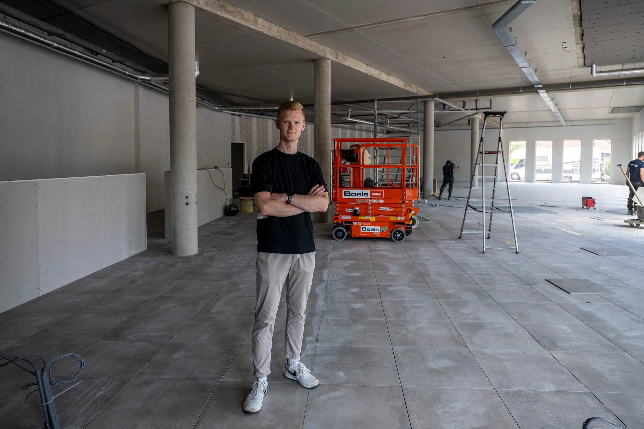 Frans op de nieuwe tegelvloer die nagenoeg gereed is in het toekomstige winkelpand. Foto: Pix4Profs/Tonny Presser
