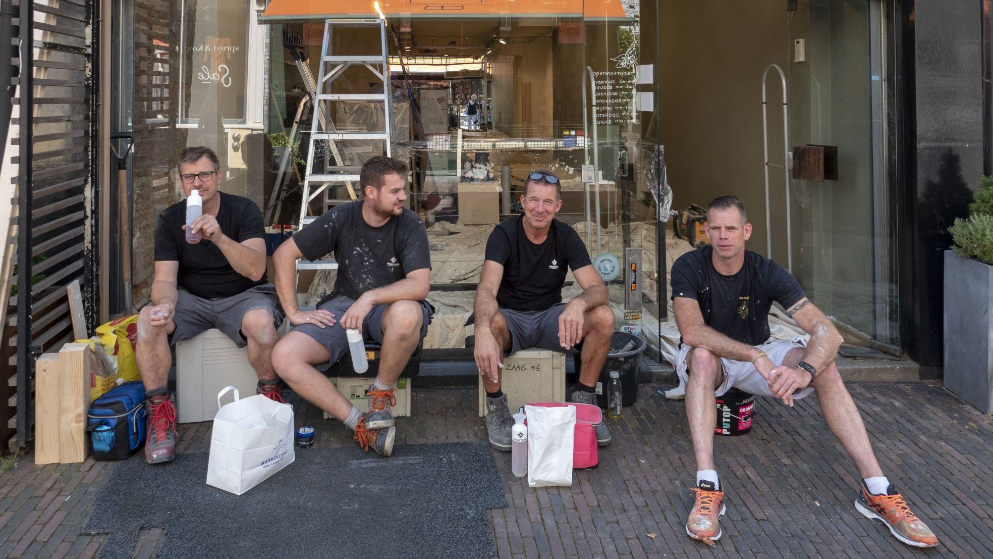 Klussers houden pauze tijdens de verbouwing van een winkelpand in de stad Utrecht.